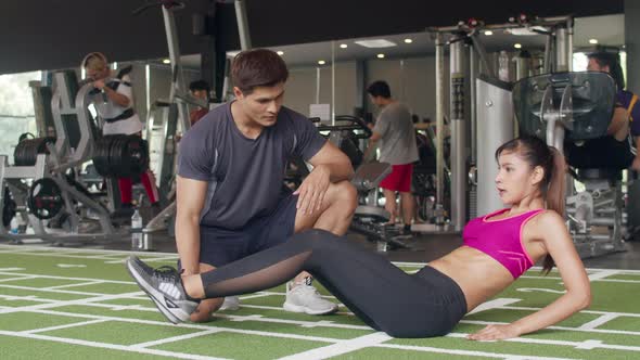Handsome asian guy personal trainer focus body weight training to lady customer.