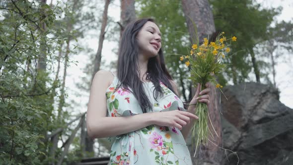 Portrait Young Adorable Woman with Long Black Hair Stand on the Wooden Stairs and Smells Wild alt