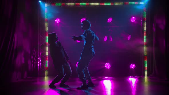 Silhouettes of a Talented Young Girl and Boy Hip Hop Dancers. Hip Hop Street Dance on a Stage in alt