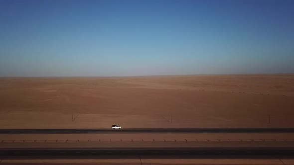 Car Parked on Asphalt Road in Aerial Desert