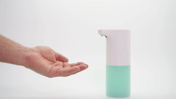 Male Hand and Automatic Dispenser, Disinfectant on an Isolated Background, Close-up. Demonstration alt