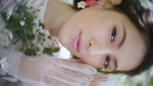 Fashion Portrait of a Young Beautiful Woman in a White Dress Standing and Posing Next to a Cherry alt