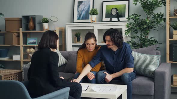 Husband and Wife Signing Agreement Taking Key From Realtor Kissing and Hugging alt