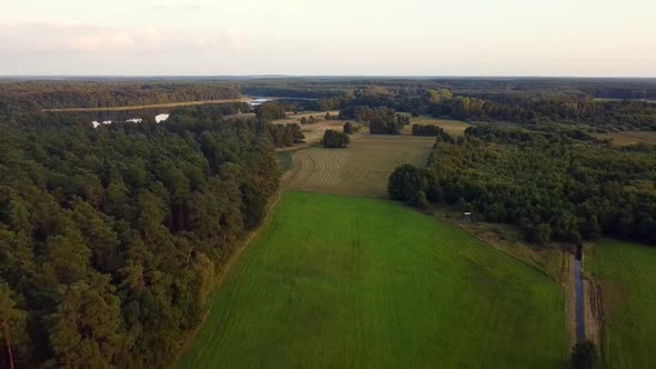 Spectacular aerial flight very high fly backwards drone shot lake and farm landin nature reserve Mü alt
