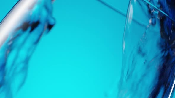 Purple Liquid Pouring in Glass at an Angle on Blue alt