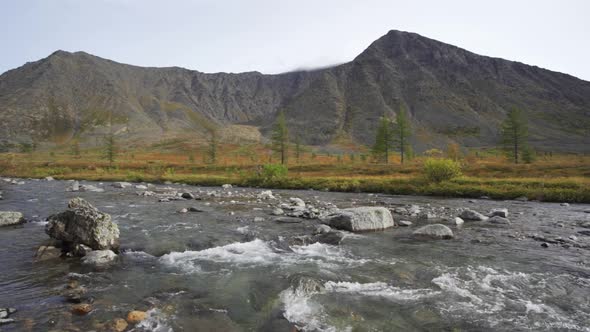 A Wide Fast River Against the Backdrop of High Mountains