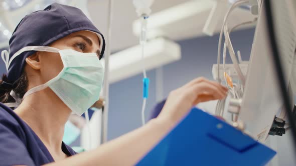 Female anesthesiologist writing down the updates alt