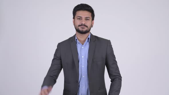 Young Handsome Bearded Indian Businessman Waving Hand alt