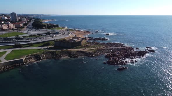 Aerial View of a Stone Cape in the Ocean and a Roundabout in Porto Portugal