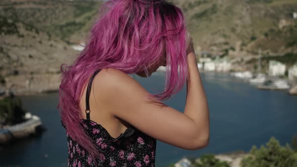Young Girl with Purple Hair Against the Backdrop of the Bay alt