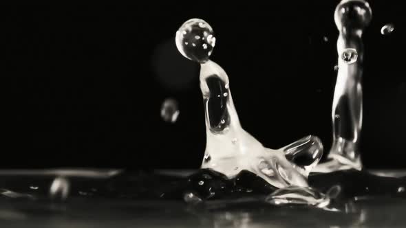 Many Drops of Water Fall on the Surface of the Water in Slow Motion Macro Shot alt