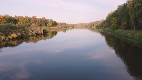 Slow Flight Over the Calm Waters of a Wide River at Sunset alt