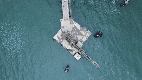 Historic coal mining platform located out in the ocean waters. Highing drone view alt