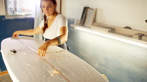 Woman making surfboard at workshop  alt