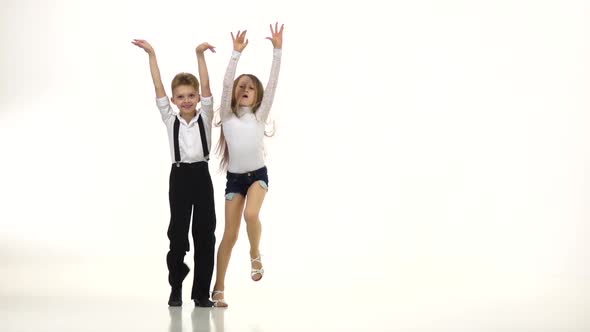 Little Dancers in Beautiful Costumes Perform a Retmic Dance, White Background, Slow Monion alt