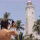 Woman Traveler in Front of Famous Landmark of Sri Lanka with Smartphone Dondra Lighthouse - VideoHive Item for Sale