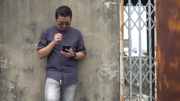 Asian men stand using mobile phones