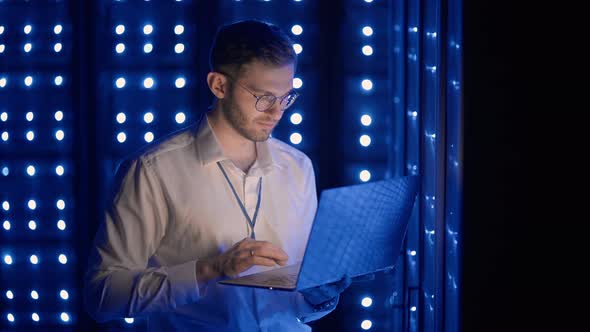 Face Portrait of Man Working in Server Room with Laptop alt