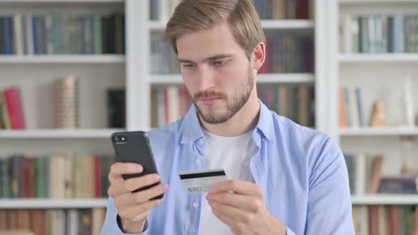 Portrait of Man Making Online Payment on Smartphone alt