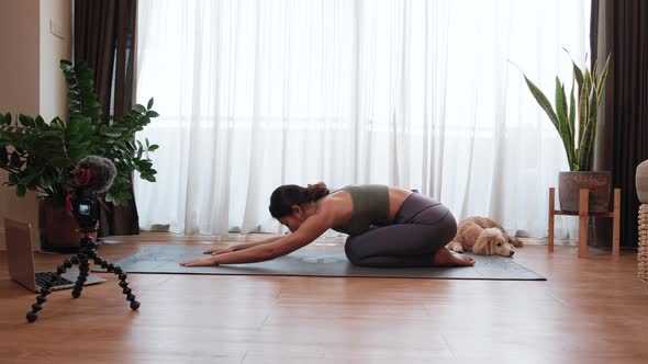 Asian woman yoga teacher filming yoga online class on video for Social media. alt
