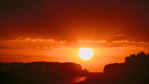 Big Sun in Vivid Beautiful Sunset Sunshine Above Summer Landscape Counrty Road And Forest alt