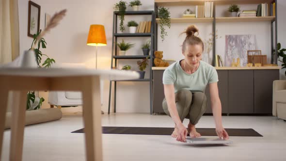 Woman Preparing to Practice Yoga with Online Instructor alt