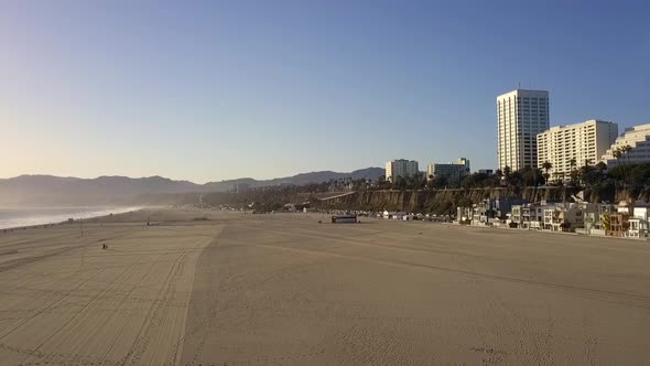Empty beach, lonely walking during sunset.Smooth aerial view flight fly backwards drone footageat alt
