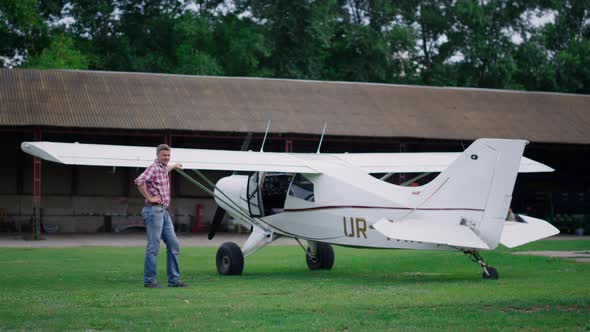 Pilot Posing Standing Airplane on Airfield alt
