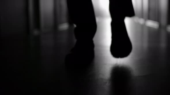 Silhouette of Legs of Walking Businessman alt