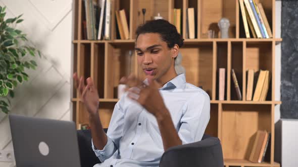 Hilarious Multiracial Guy Using Laptop for Remote Video Connection alt