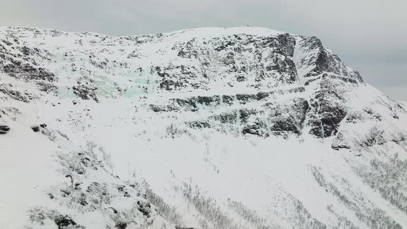 Snowy Rocky Mountain Summit In Winter Landscape In Norway, Aerial alt