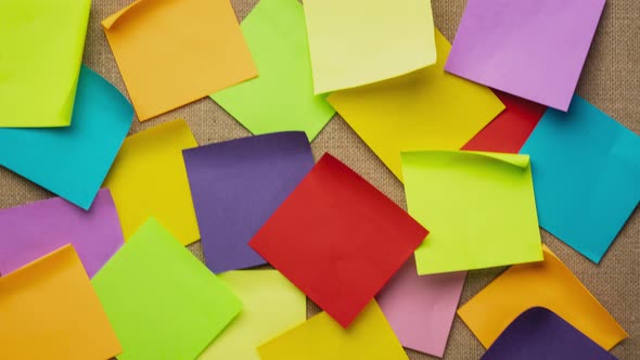 Colorful blank sticky notes being dropped onto canvas board alt