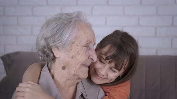 Happy child hugging grandmother.  alt
