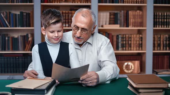 70s Grandfather Help Doing Homework Little Cute Male Grandkid Sitting on Vintage Table Home Library alt