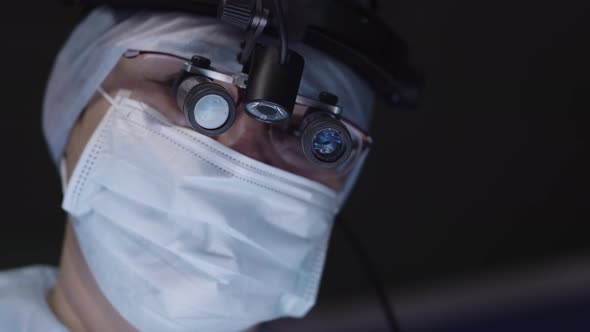 Doctor with surgical loupe looking at camera