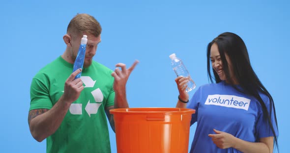 Eco-conscious Man and Woman Putting Bottle Into Bucket alt