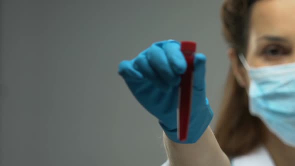 Female Doctor Holding Test Tube With Blood Sample, Infectious Disease Awareness alt