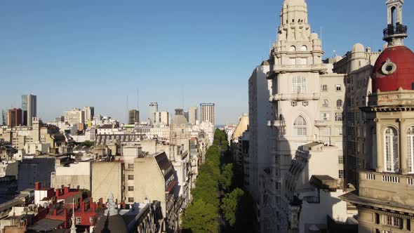 Cinematic aerial dolly in above May avenue alongside with heritage building Barolo Palace in downtow alt