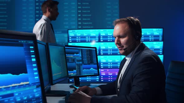 Team of brokers is working in office using workstation and analysis technology. alt