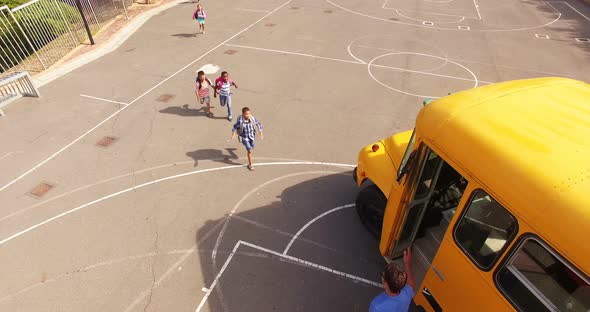 Teacher giving high to kids while entering in bus alt