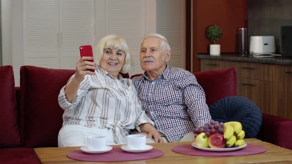 Senior Family Having Fun, Making Selfie Photos, Recording Video Together on Smartphone at Home alt