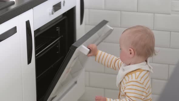 Curious Little Baby Opening Oven at Home in Kitchen alt
