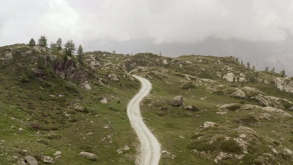 Cinematic Aerial View Gravel Trail Road on the Mountain alt