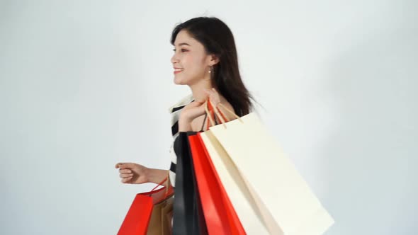 slow-motion of happy woman walking and holding shopping bag