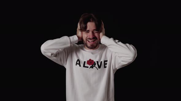 Trendy Young Man covering ears, loud hearing gesture, wide, black background alt
