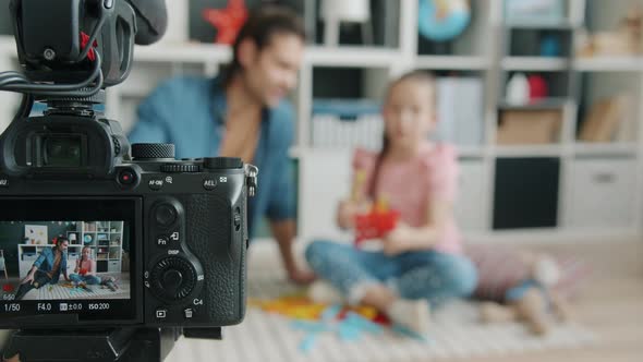 Closeup of Camera Display Recording People Father and Daughter Talking About Toys Waving Hand alt