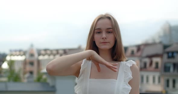 Portrait of the Young European Woman with Nose Earring in White Dress in the City She Smiles alt