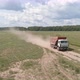 A truck full of hay drives on a dirt road across a field.15 - VideoHive Item for Sale