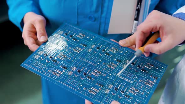 Male and Female Hands Hold the Electronic Computer Board and Show on Its Details. Close Up. Computer alt