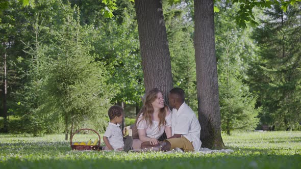 Black Father Fairskinned Mother and Mestizo Child in the Park alt